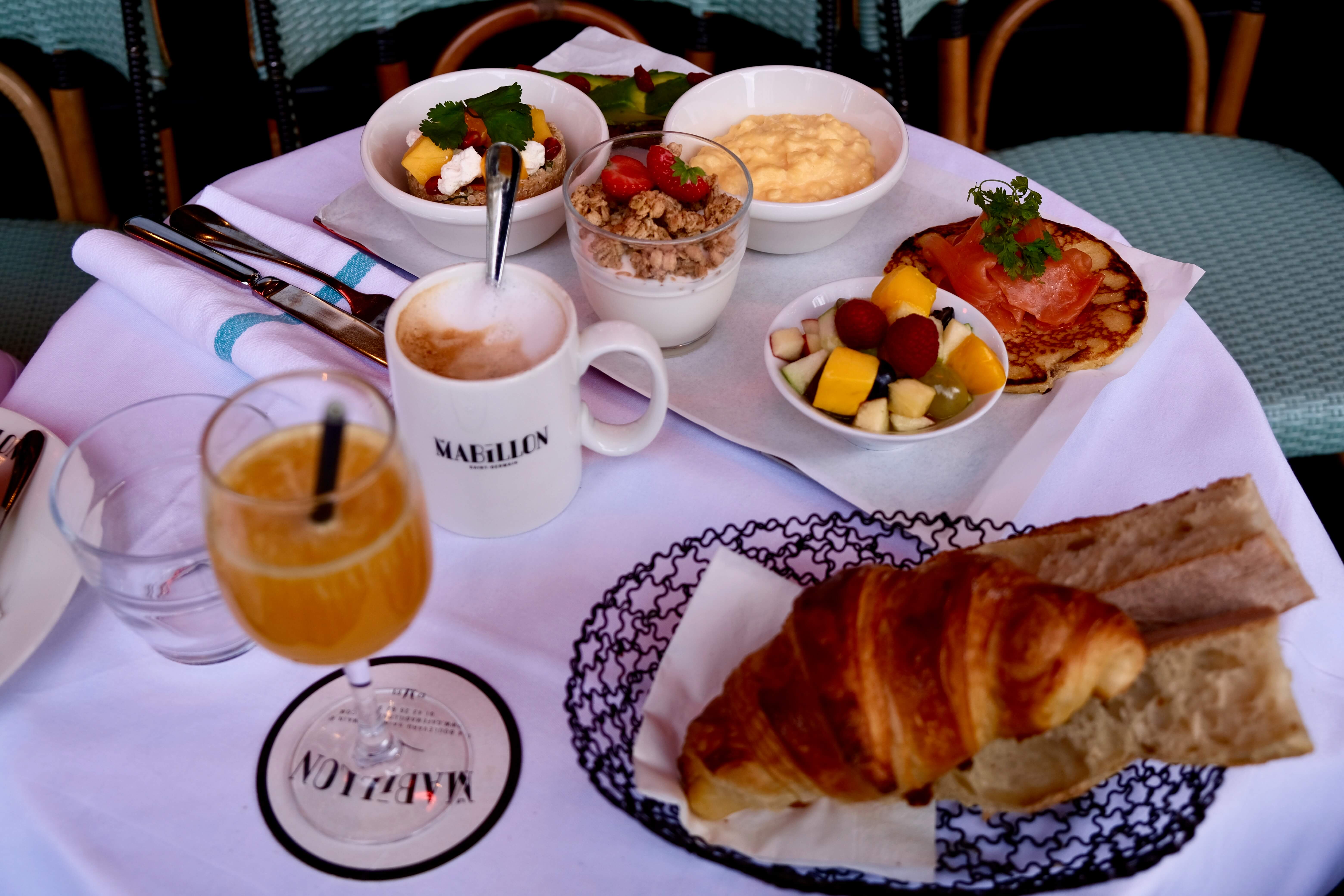 Brunch au restaurant Mabillon Paris avec croissant, pain frais, jus d’orange, café et assiettes sucrées salées.